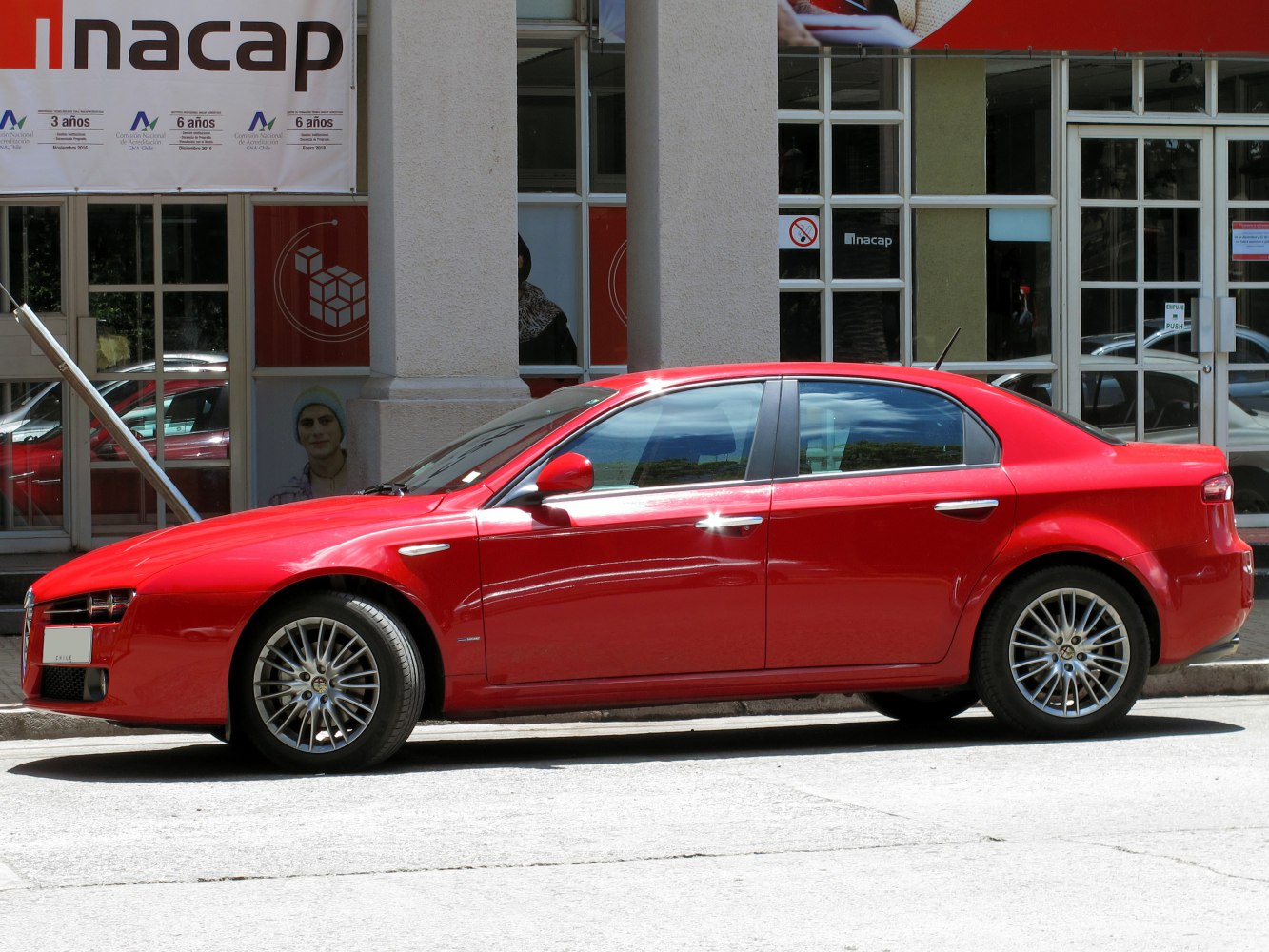 Side profile of sporty red four-door sedan with alloy wheels