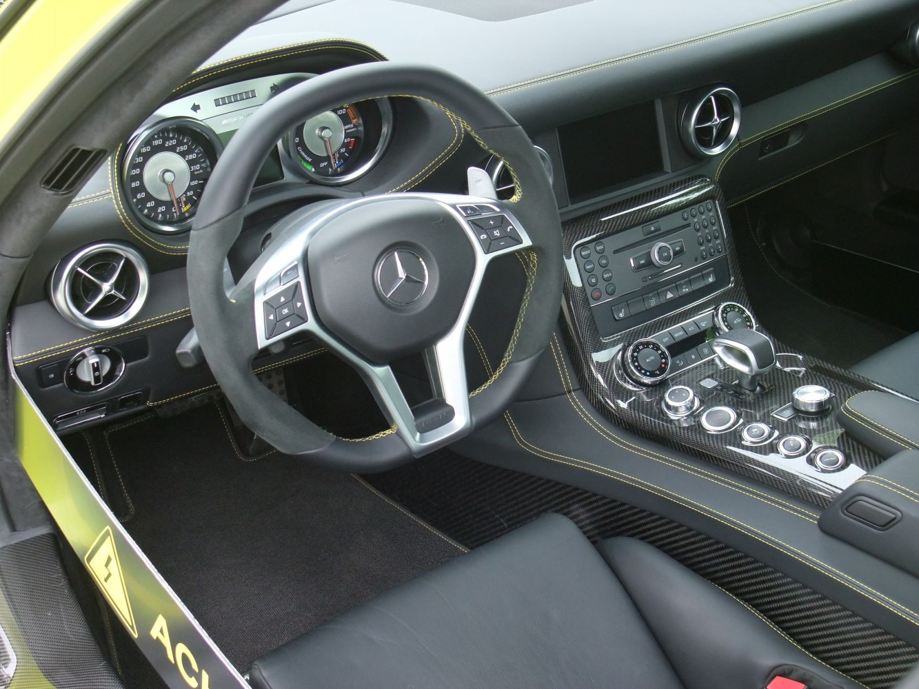 Sport steering wheel with carbon fiber center console and yellow contrast stitching