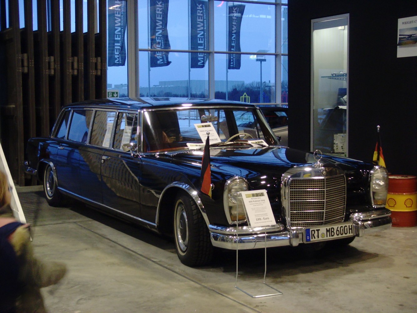 Luxury limousine with twin front flags and large chrome grille
