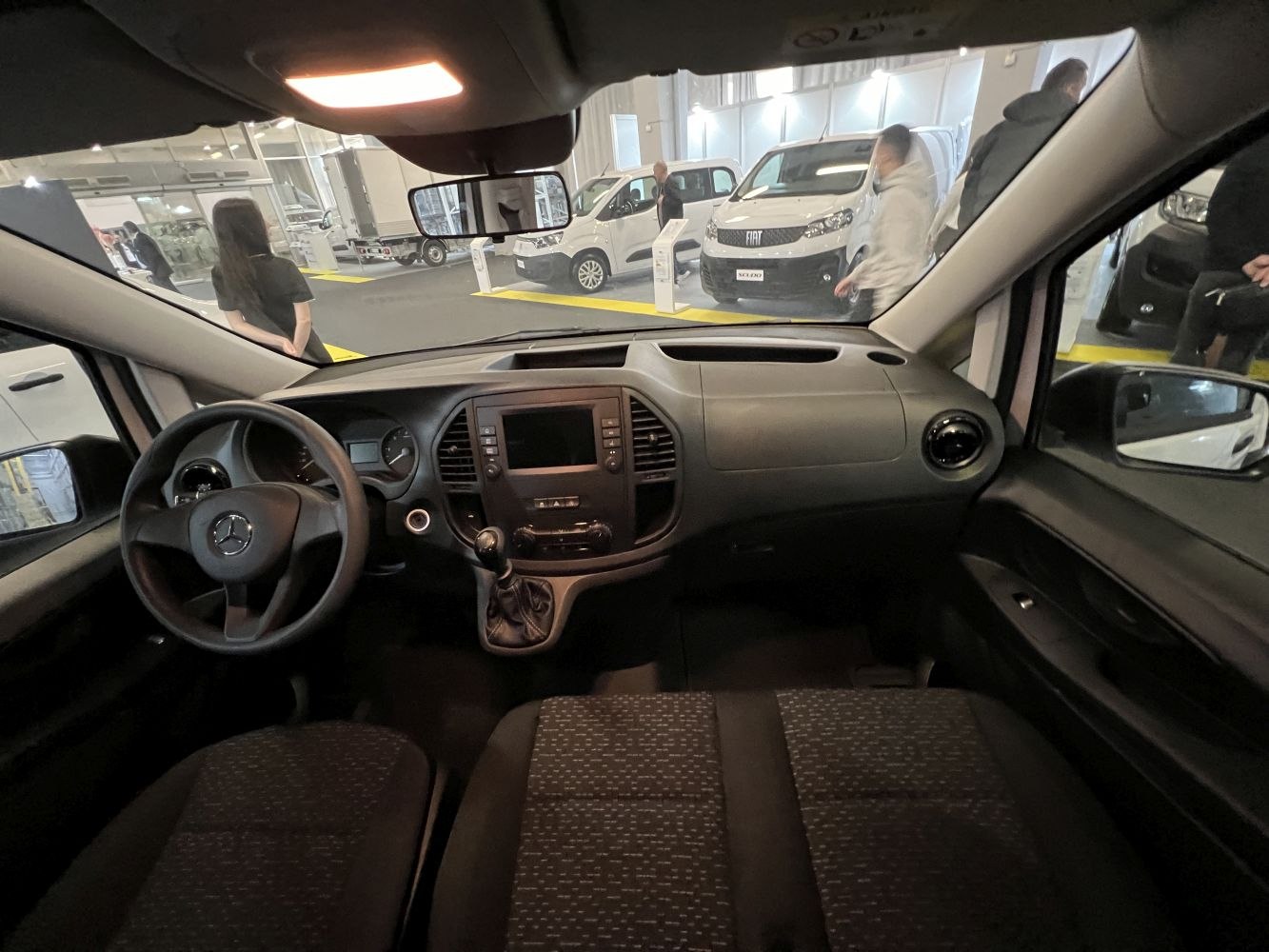 Dashboard and seats interior view with manual gear lever and steering wheel