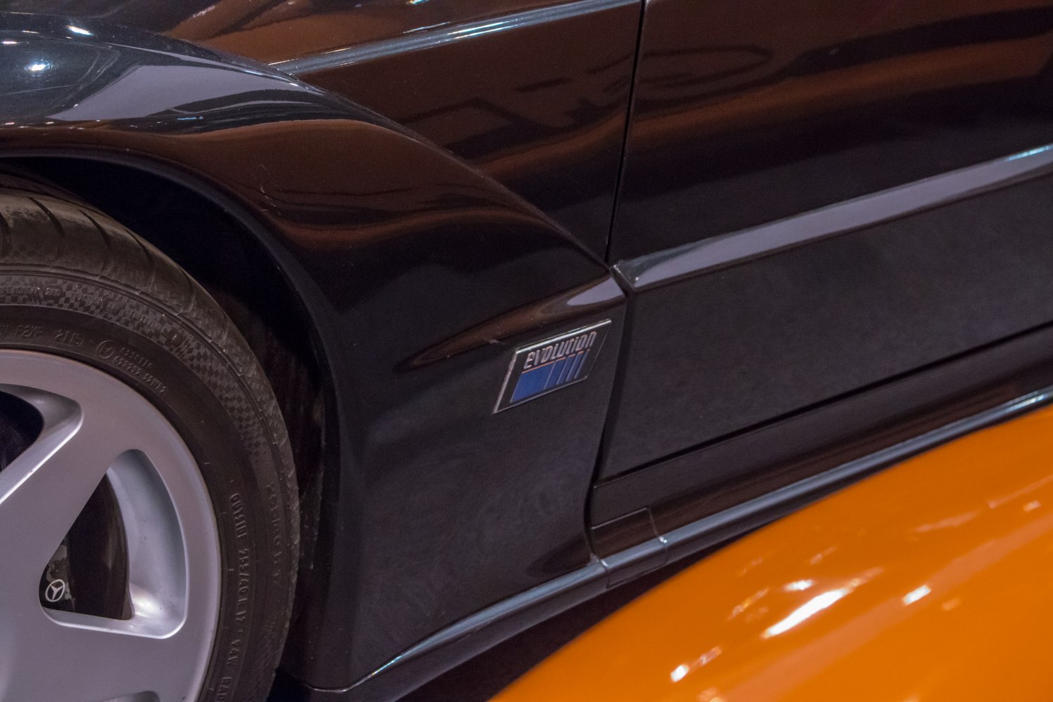Close-up of wheel and evolution badge on black car fender