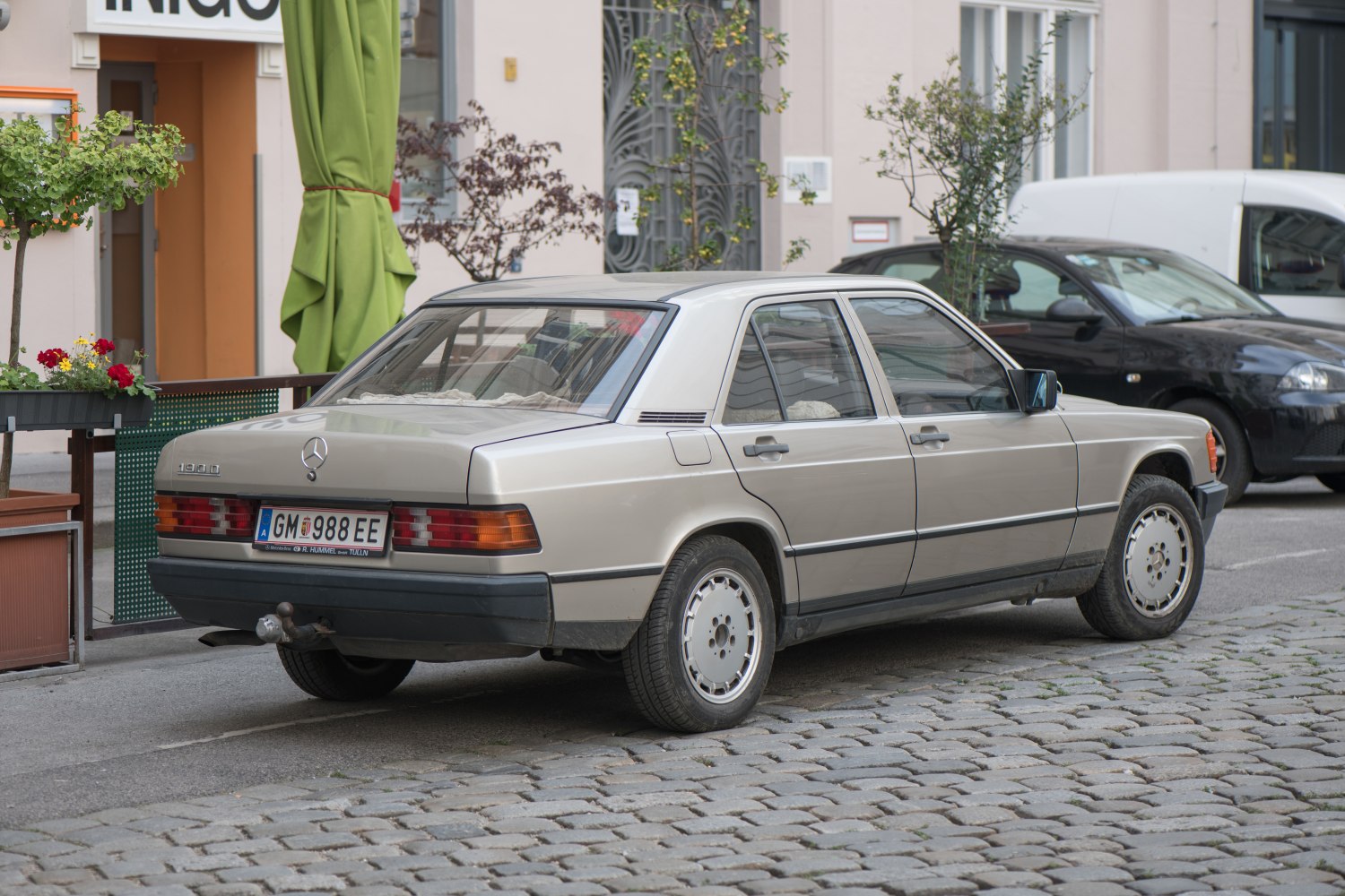 Rear angle view of a vintage compact sedan with classic taillights and alloy wheels.