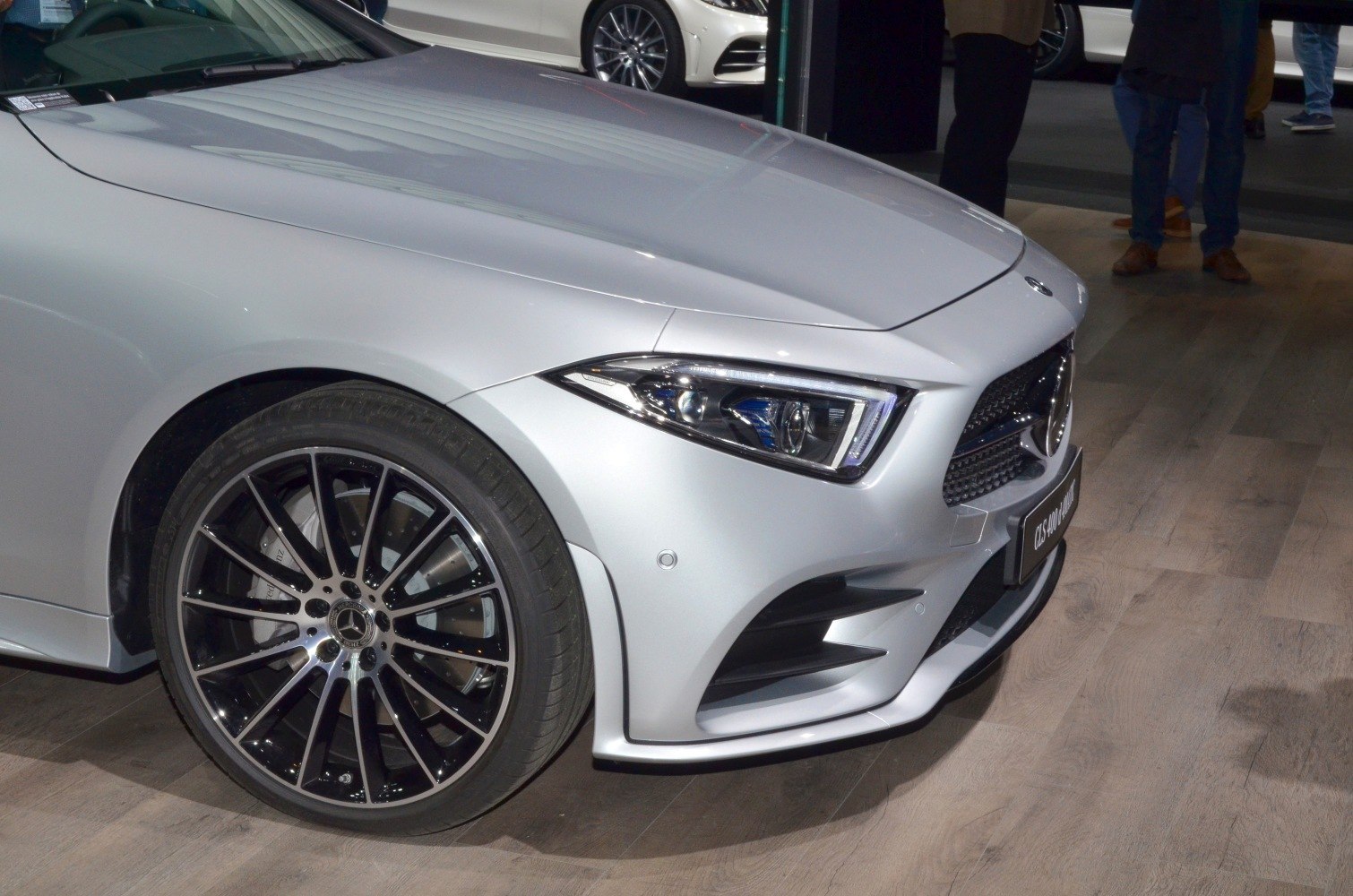 Front headlight and stylish alloy wheel of a silver luxury coupe car