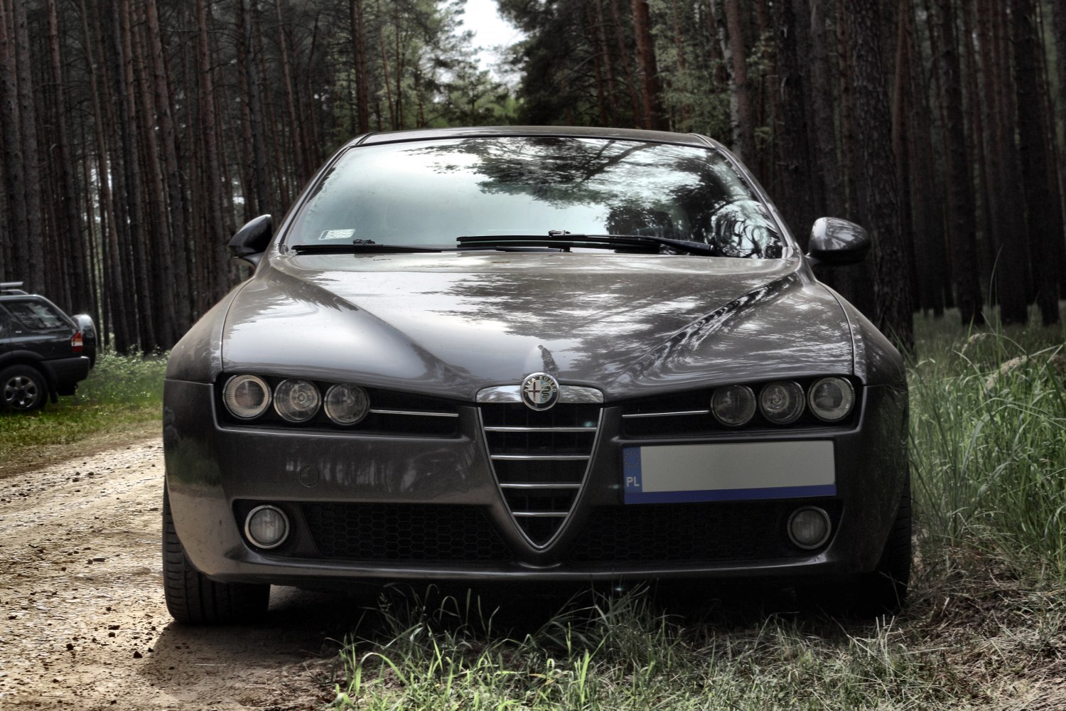 Close frontal view with triple headlights and signature V-grille