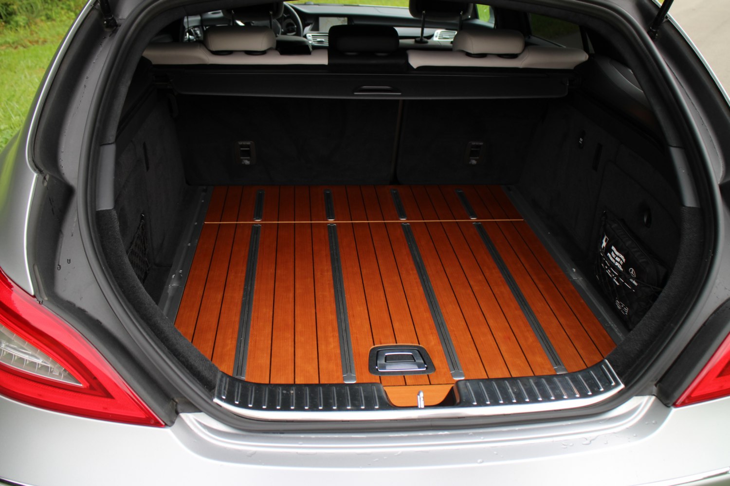 Spacious trunk with elegant wooden floor and metal support rails