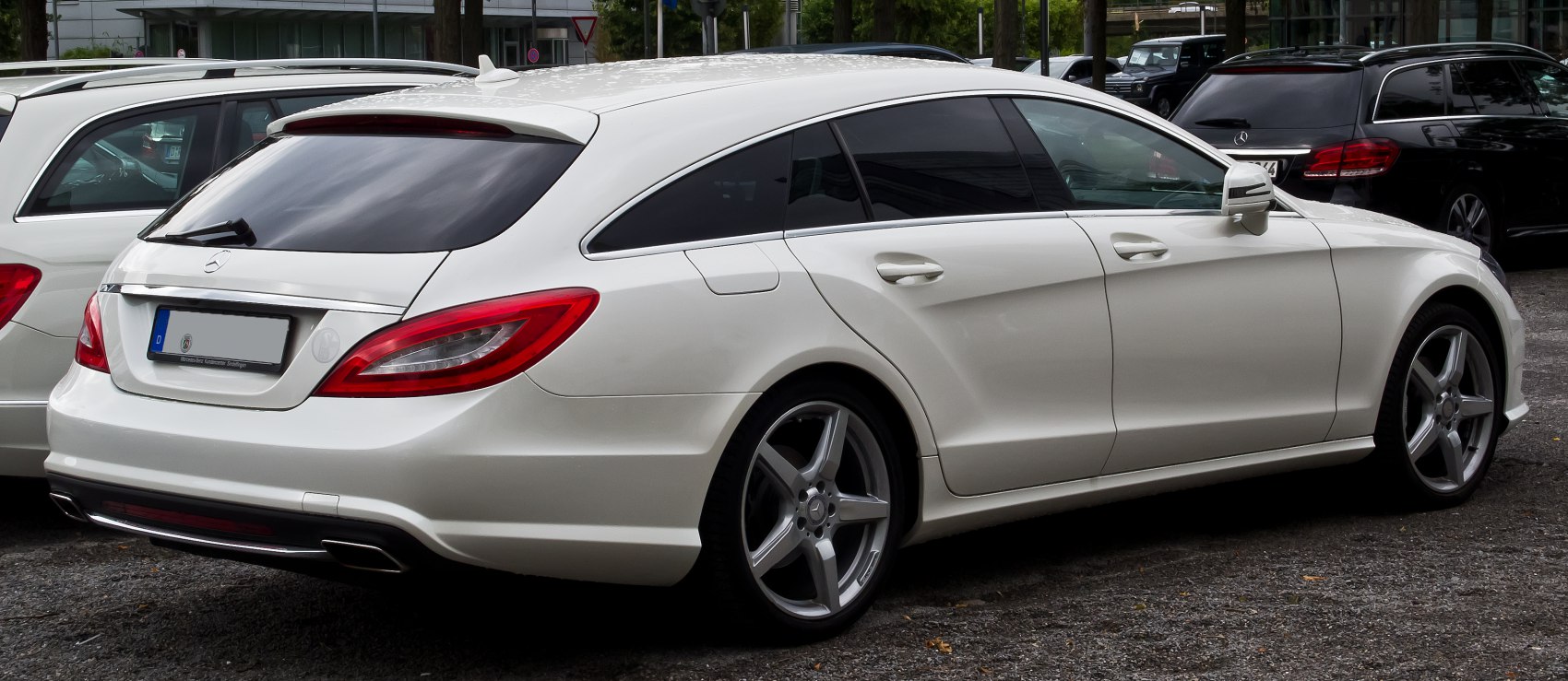 Rear and side profile of a sleek, white estate with distinctive taillights and alloy wheels