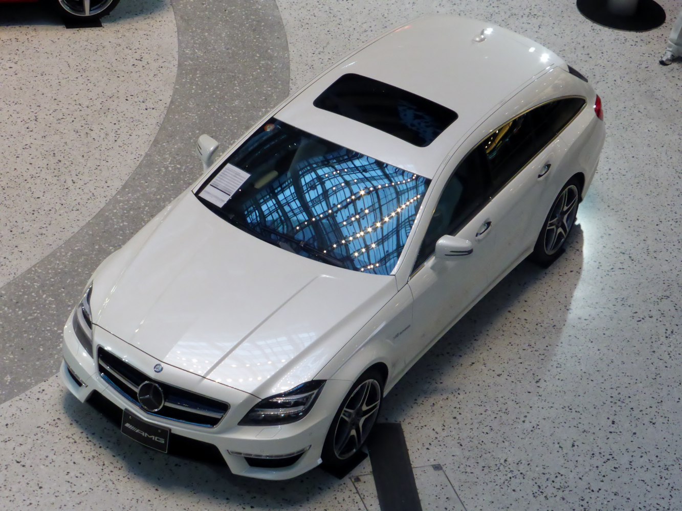 Top-down white car with sunroof, sleek elongated roofline, and AMG styling.