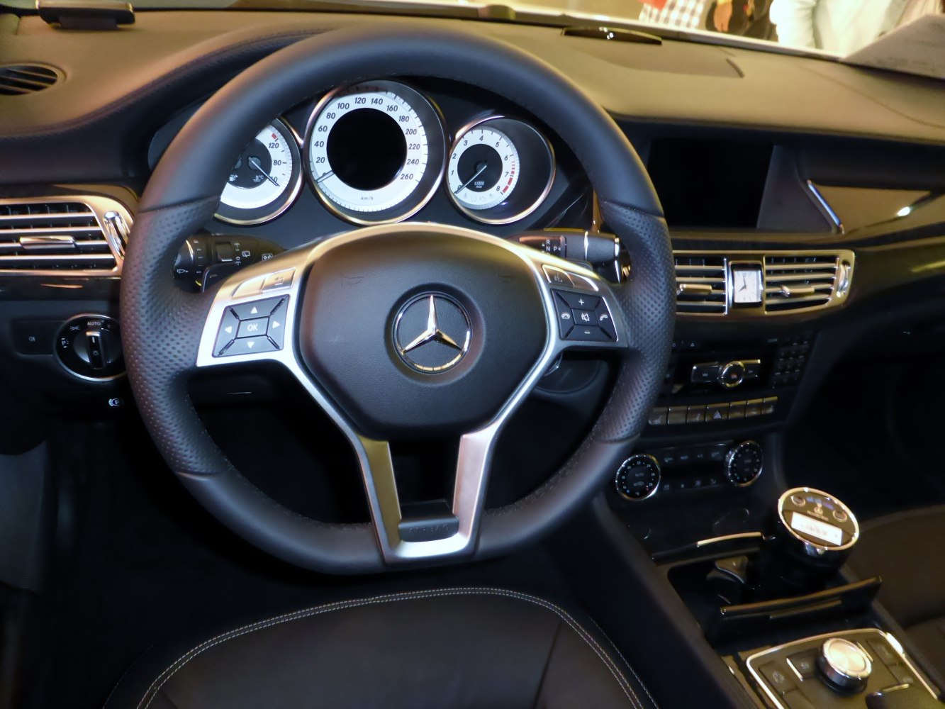 Luxury steering wheel and dashboard with analog gauges and control panel