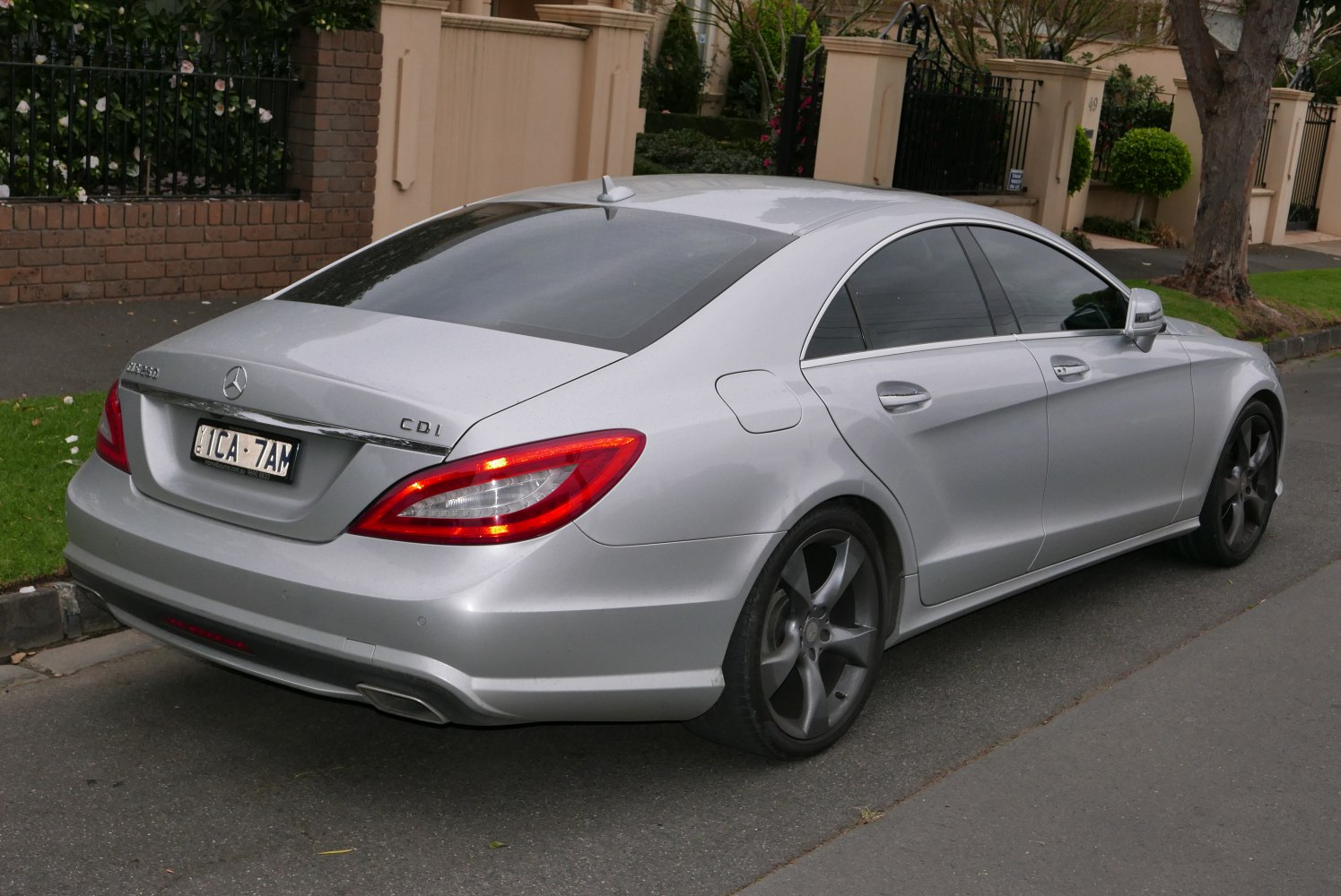Rear and side view of silver luxury coupe with tinted windows and alloy wheels