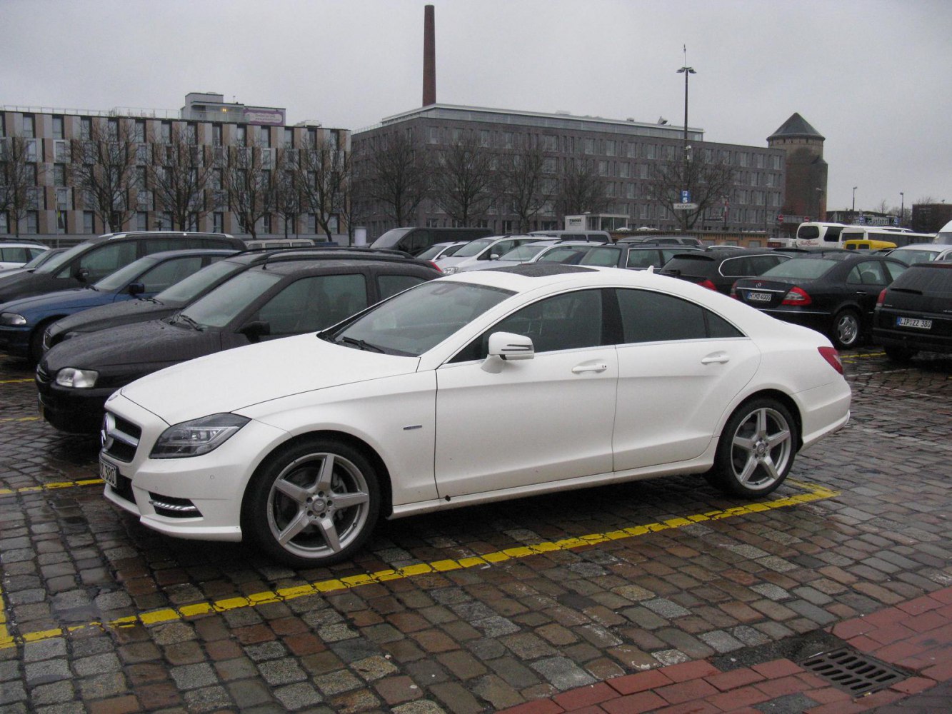 White luxury four-door coupe with sleek side profile and alloy wheels