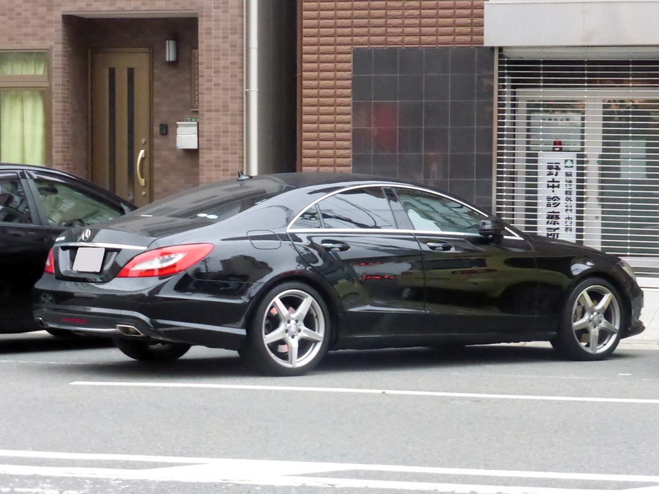 Black luxury four-door coupe with alloy wheels and integrated exhaust tips