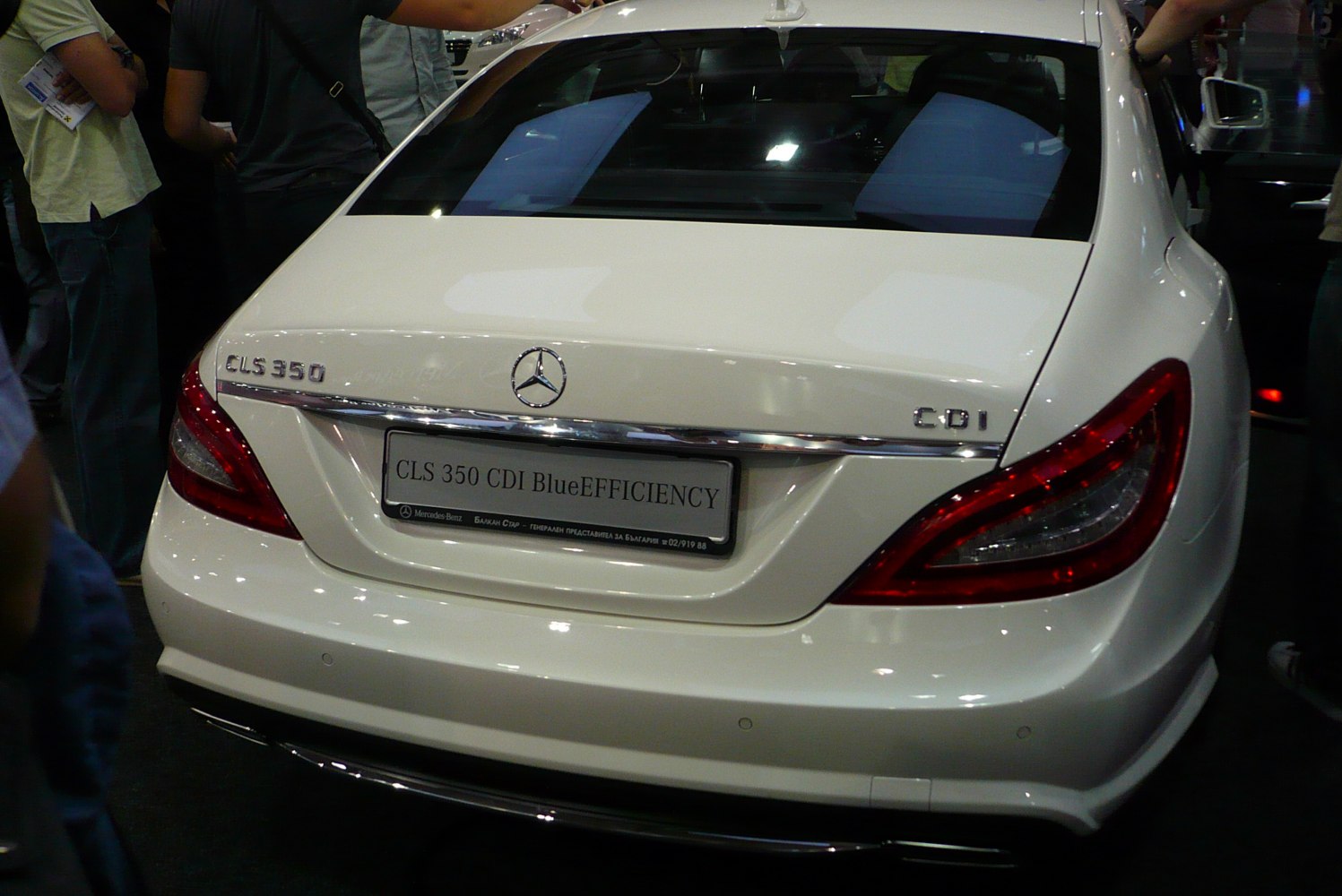 White luxury coupe rear with distinctive taillights and badges
