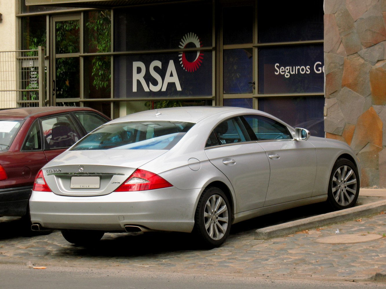 Rear and side view of a silver luxury coupe with dual exhausts