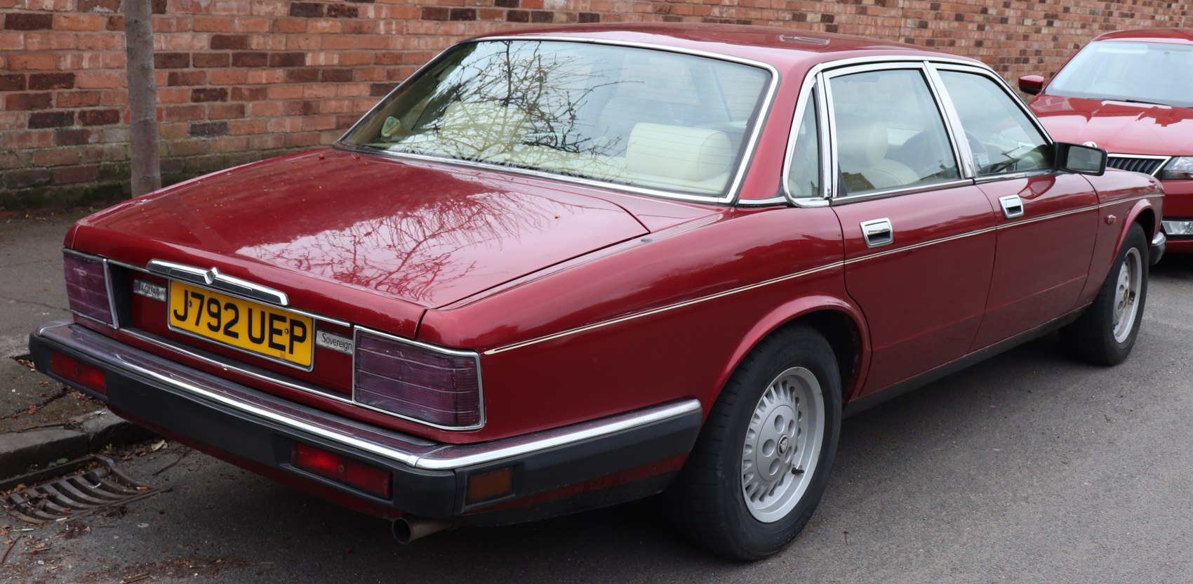 Vintage luxury sedan rear view with chrome trim and alloy wheels