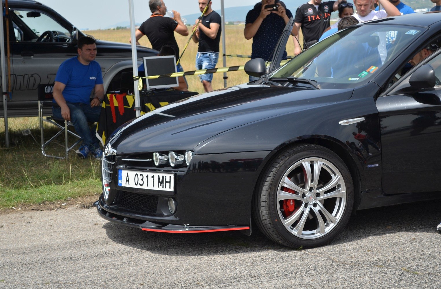 Front view focusing on alloy wheel with red brake caliper and sleek bumper design