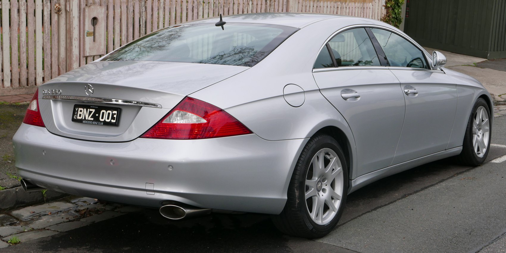Silver luxury coupe rear side with tail lights and dual exhausts