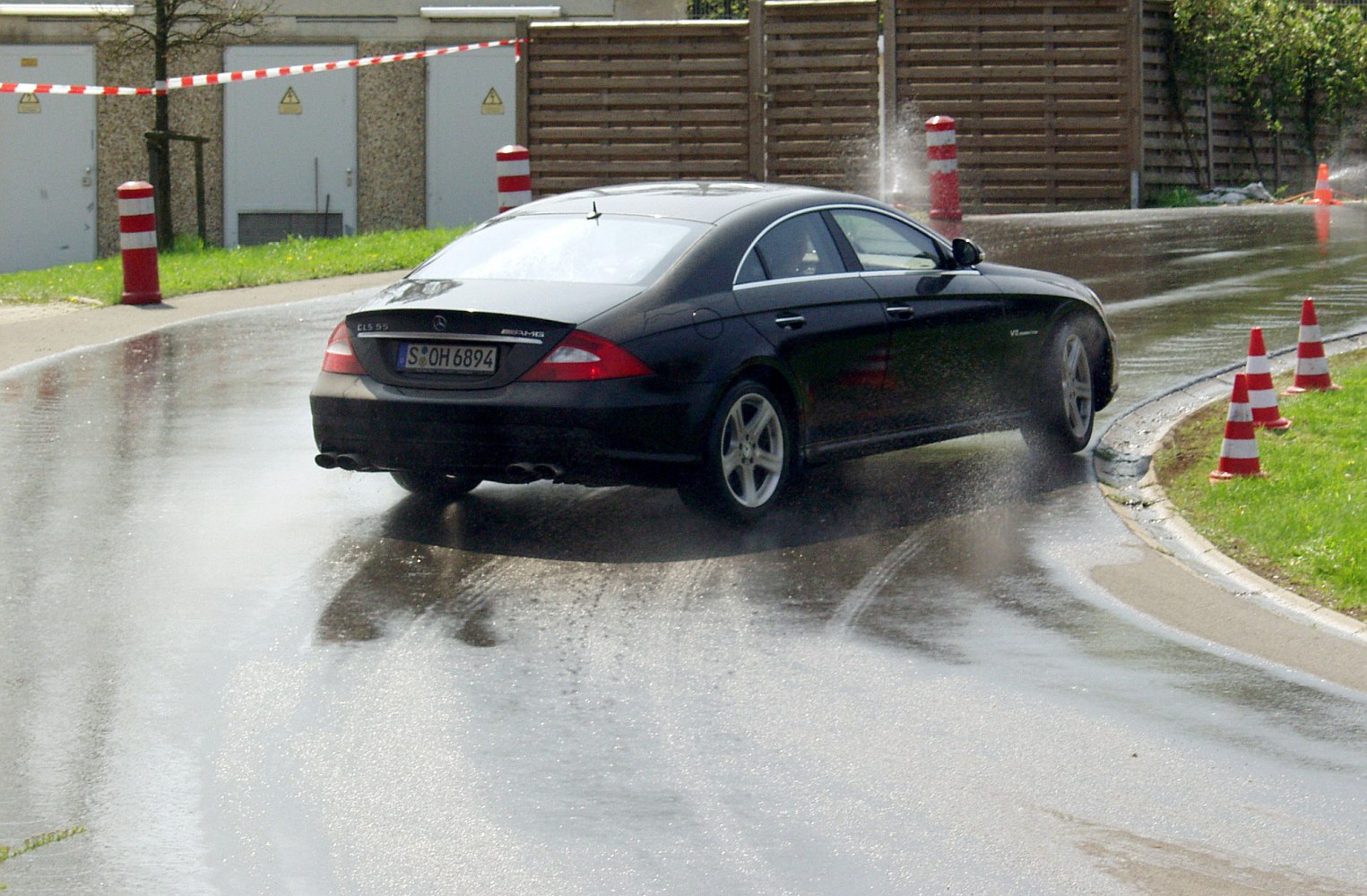 Rear of a car in dynamic motion on a wet road with water spray