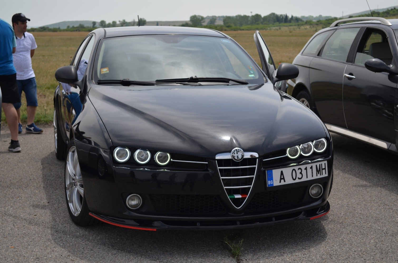 Front grille and circular LED headlights of a black sedan
