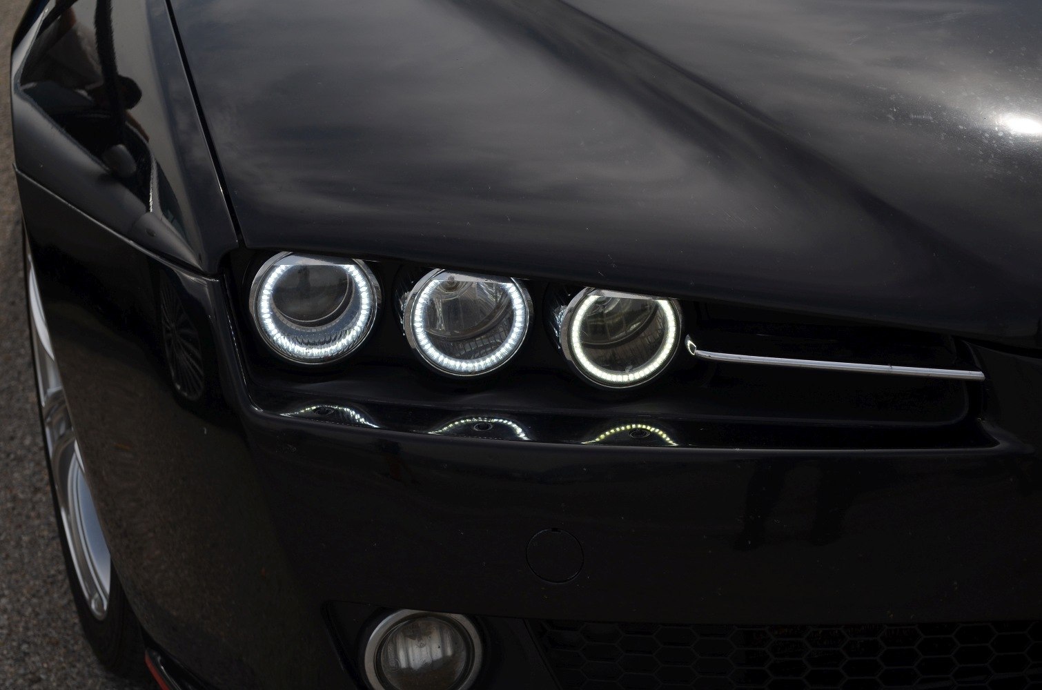 Triple circular LED headlights on black front hood