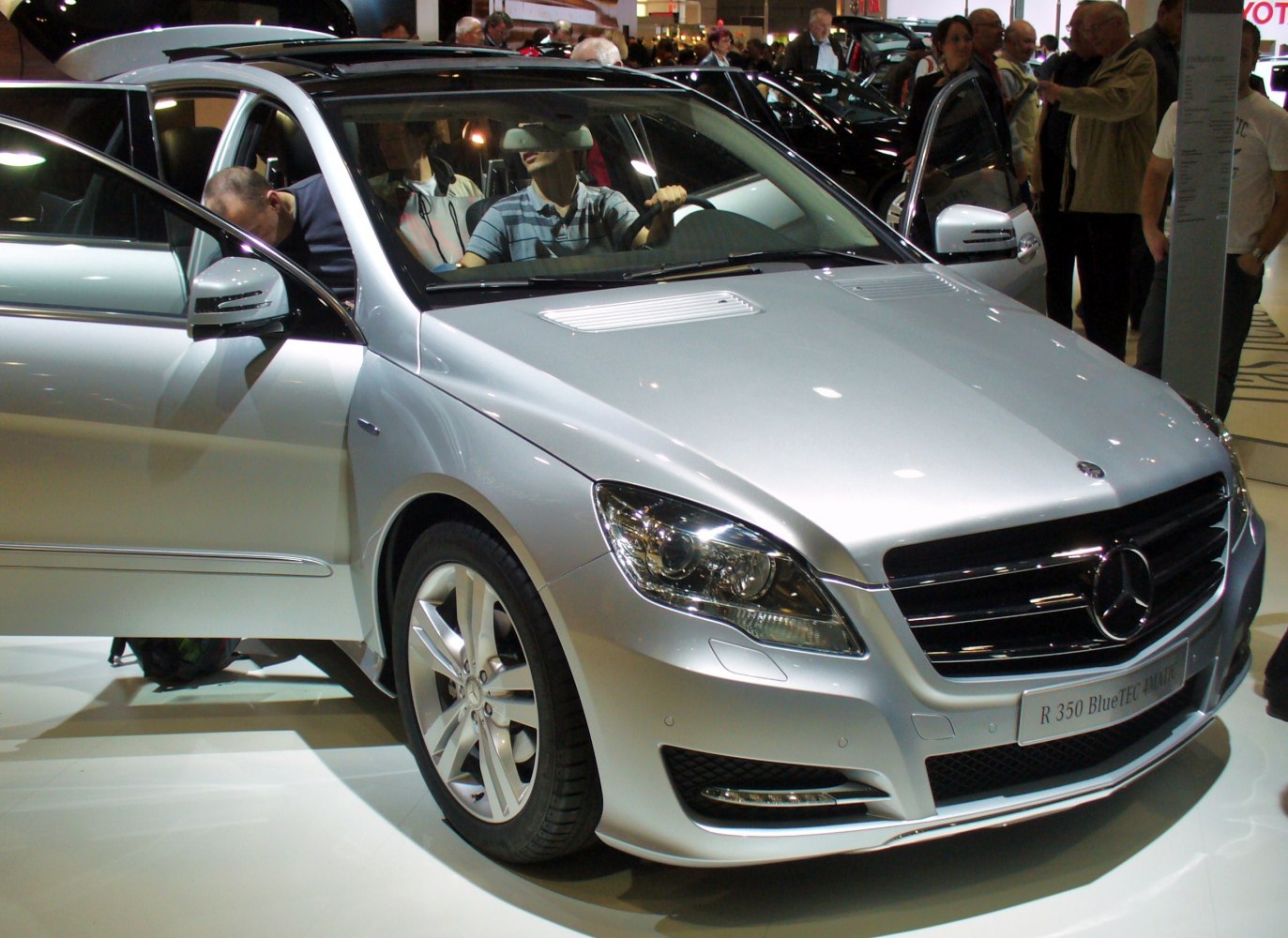 Front view of silver vehicle with open doors and detailed headlights