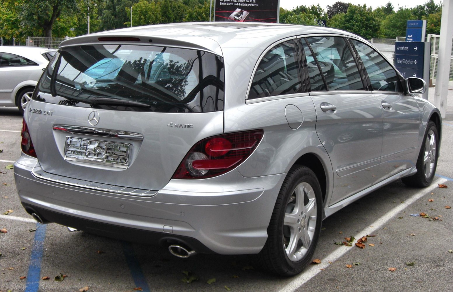 Rear view of silver MPV with 4MATIC badges and dual exhaust