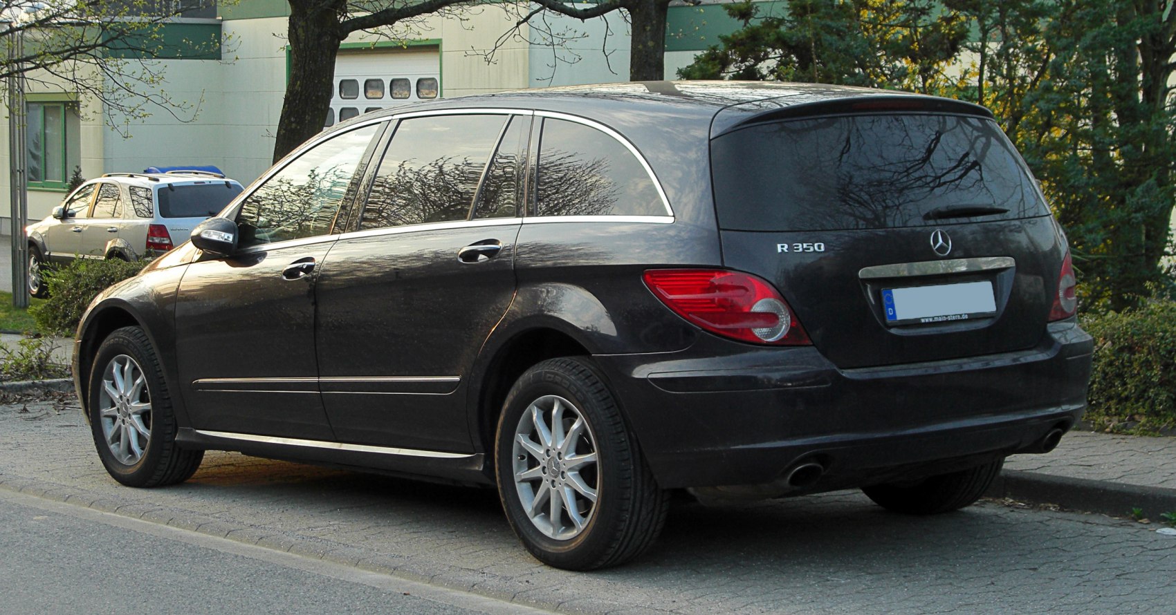Rear side view of black luxury large MPV with alloy wheels