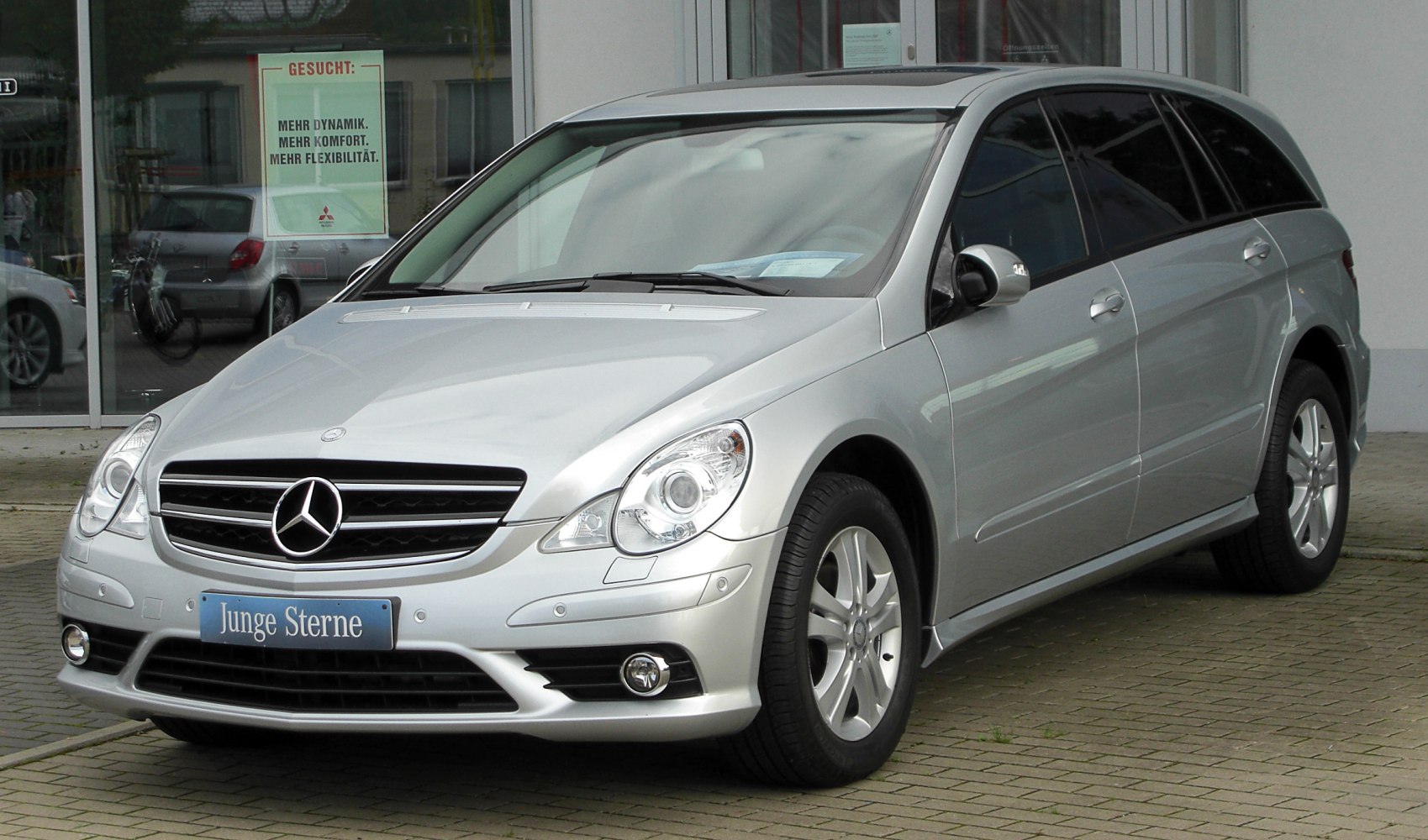 Silver luxury MPV front with distinctive headlights and grille