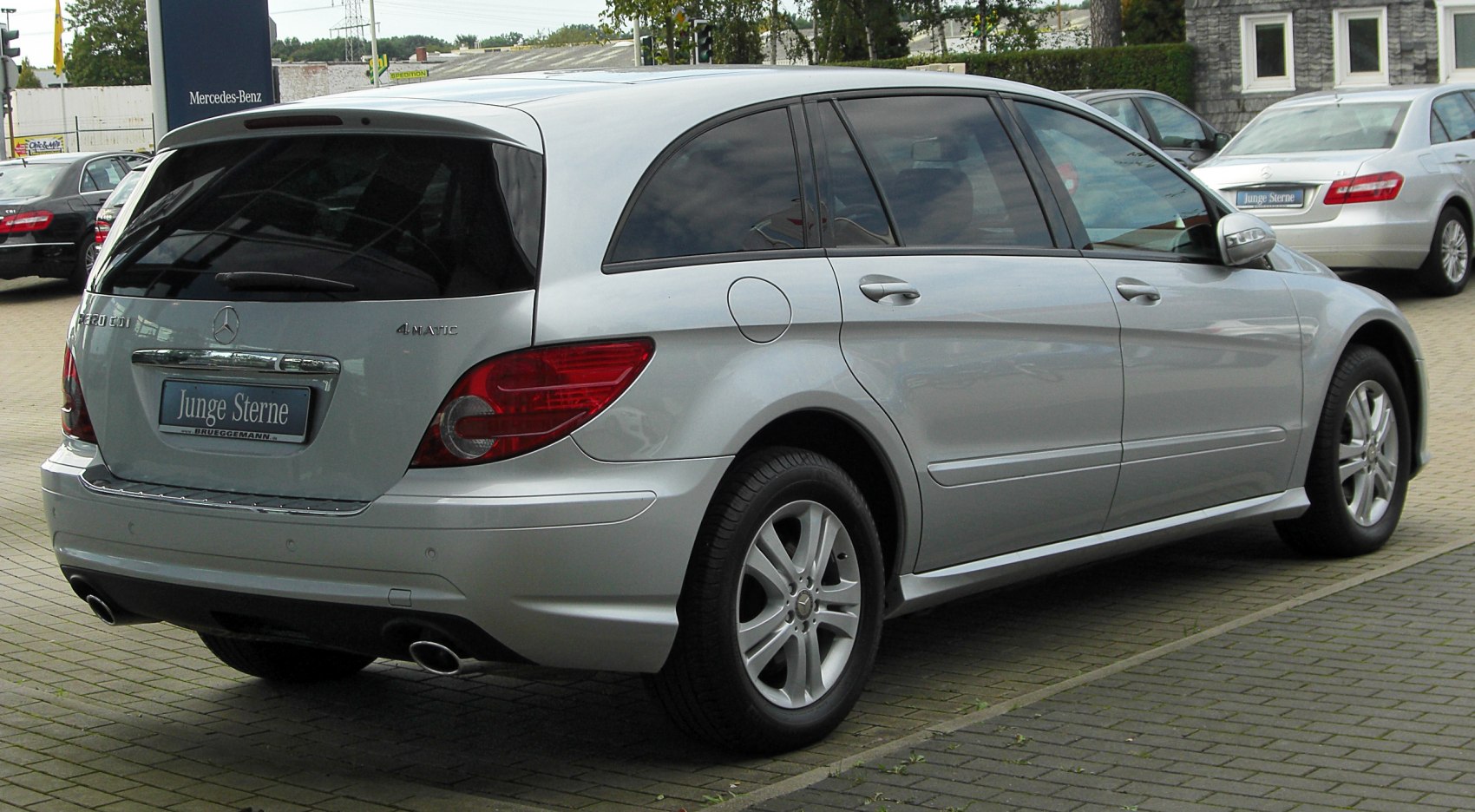 Silver rear-side view of a long-body SUV with dual exhaust and tinted windows