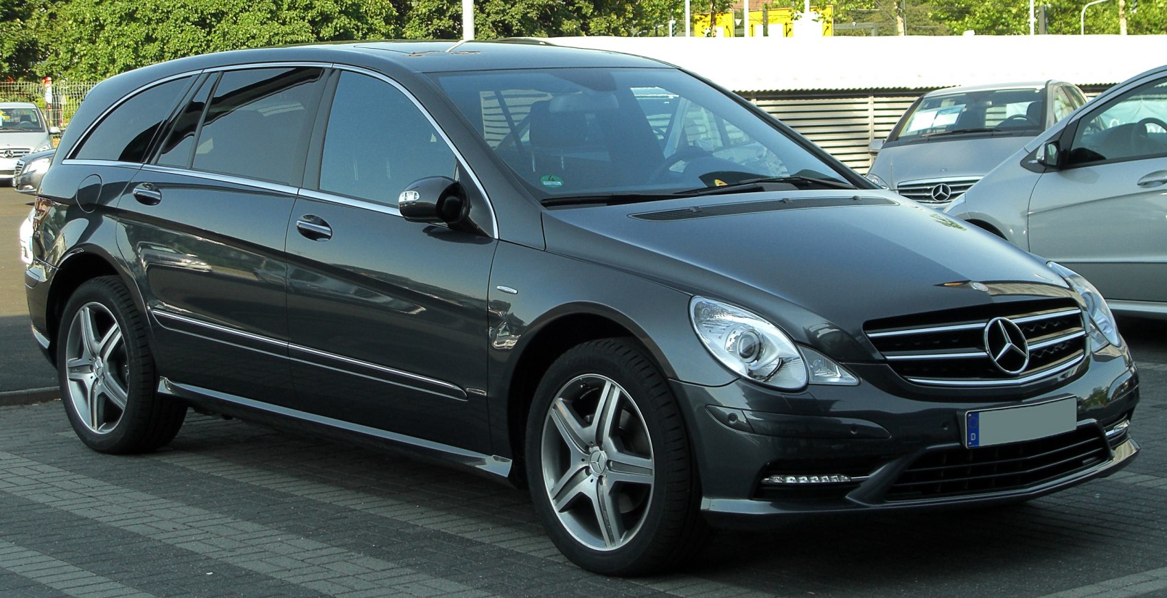 Front-side view of elongated luxury wagon with alloy wheels and modern headlights.