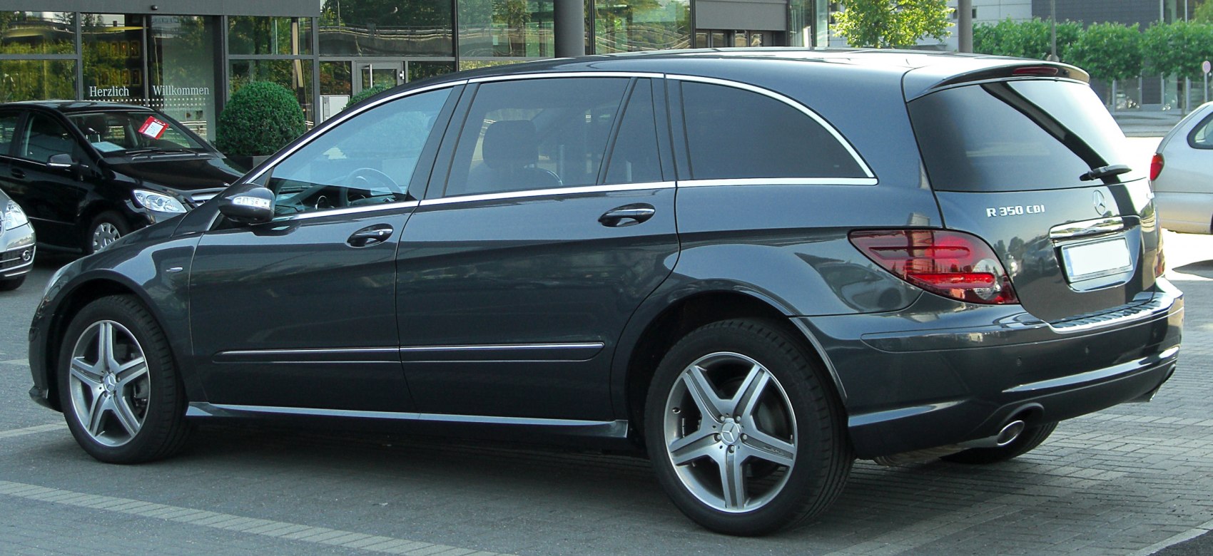 Rear side profile of a long luxury vehicle with alloy wheels and tinted windows.