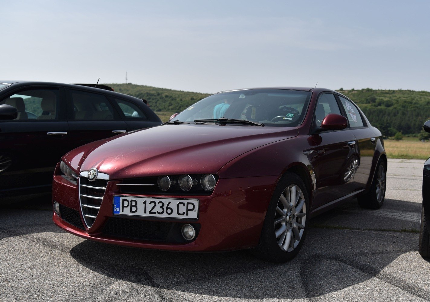 Front and side view of sedan with distinctive headlights and grille