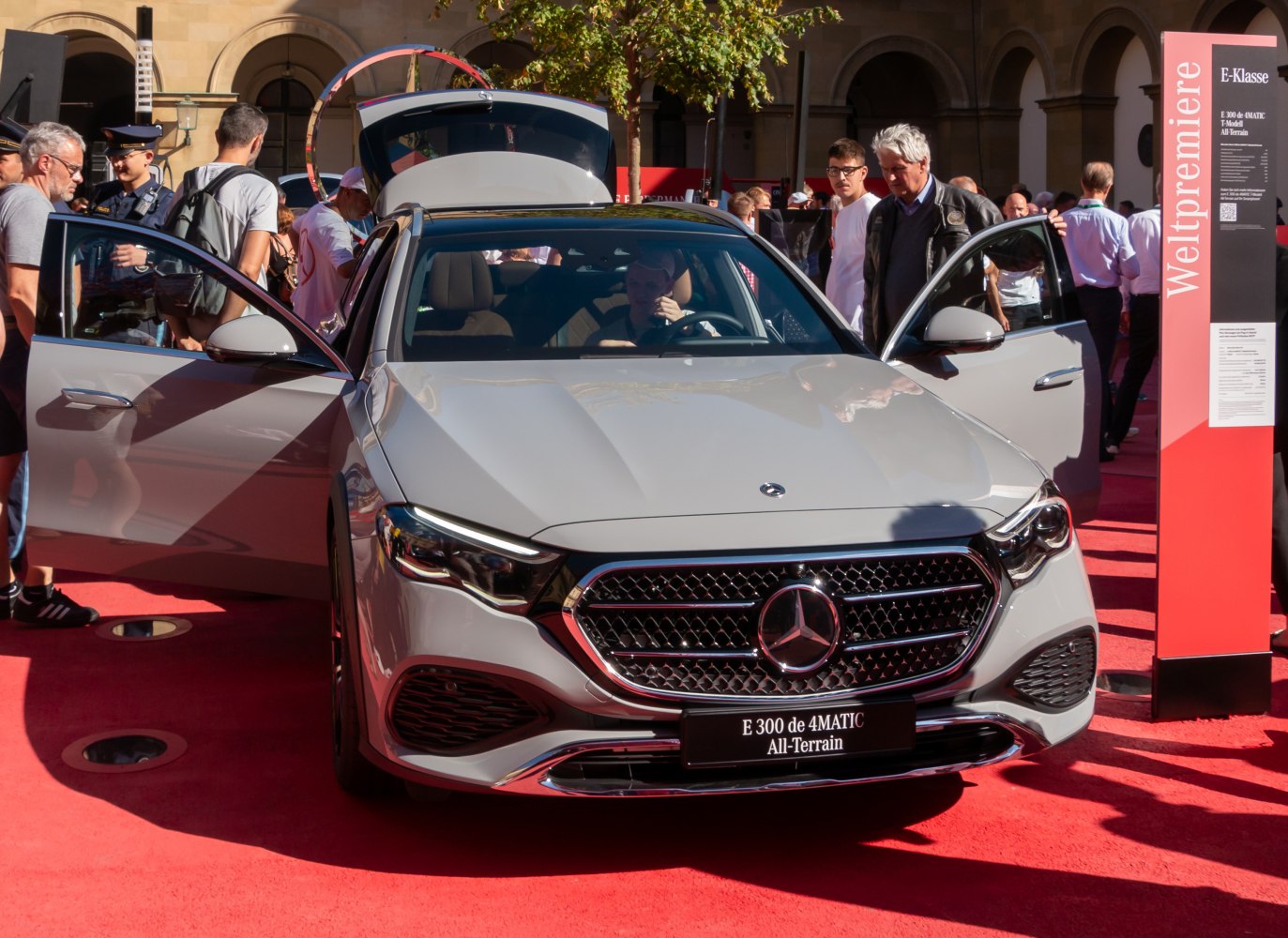 Front grille, open doors, modern headlights, and car interior