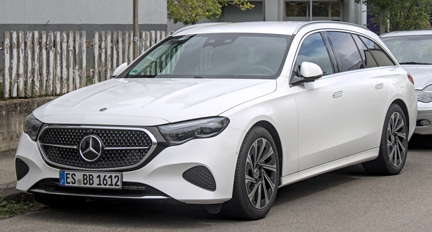 Front and side view of a white modern luxury wagon with distinctive grille and headlights