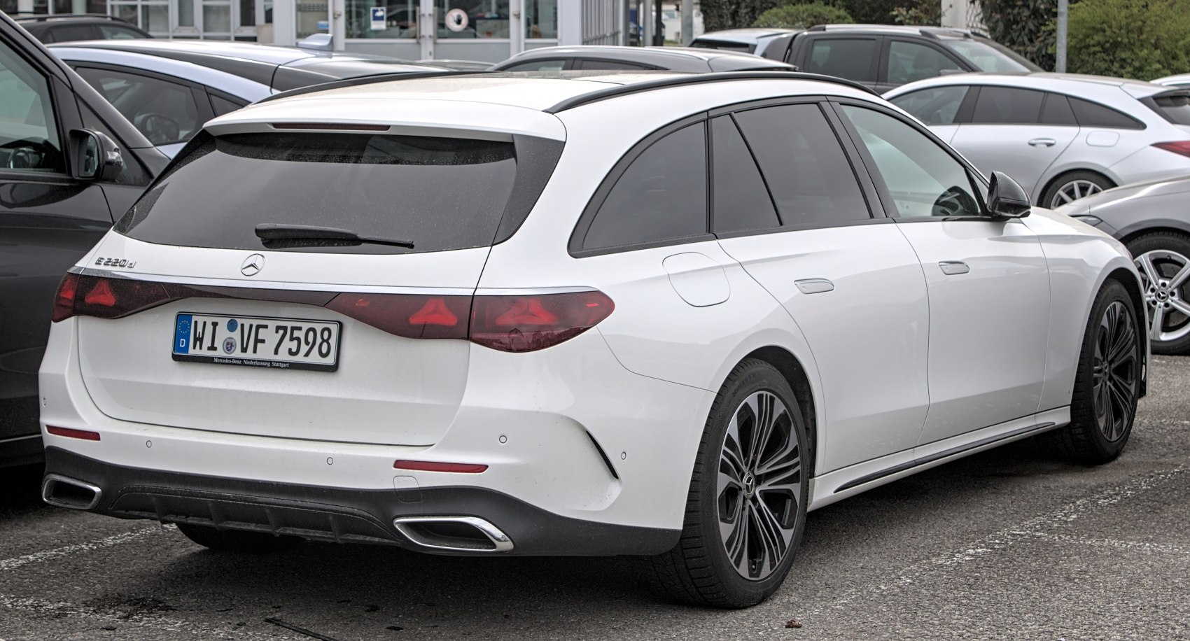 Rear side view of white luxury station wagon with LED taillights and dual exhaust