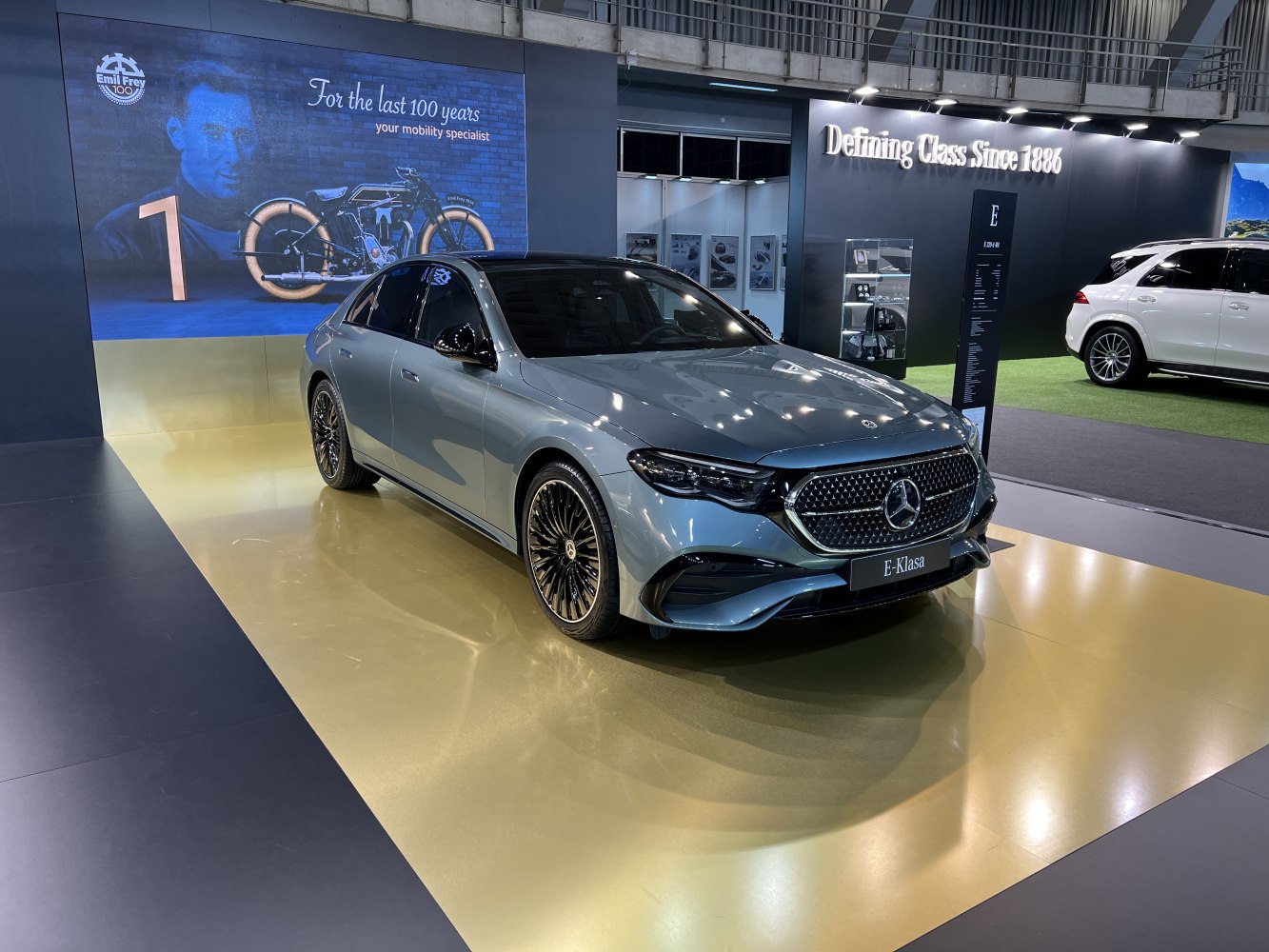 Luxury sedan front with intricate grille and multi-spoke alloy wheels