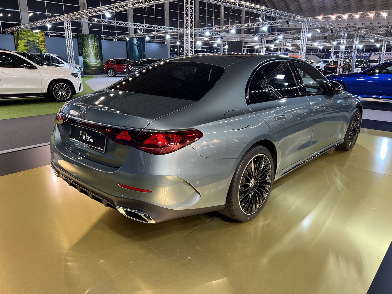 Sleek luxury sedan rear with LED taillights and multi-spoke black alloy wheels