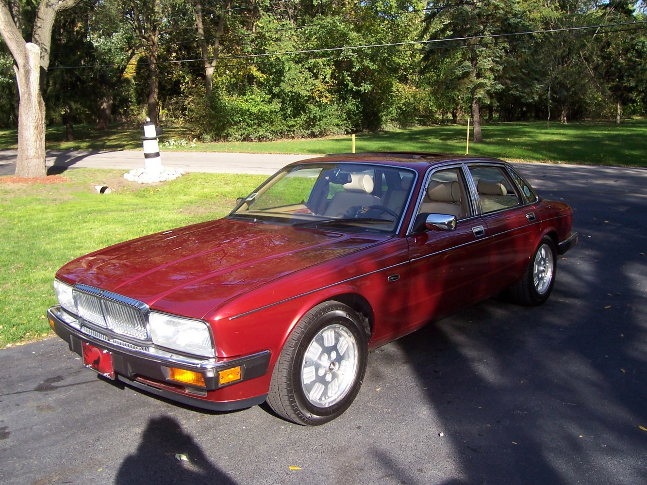 Classic luxury sedan with distinctive grille, alloy wheels.