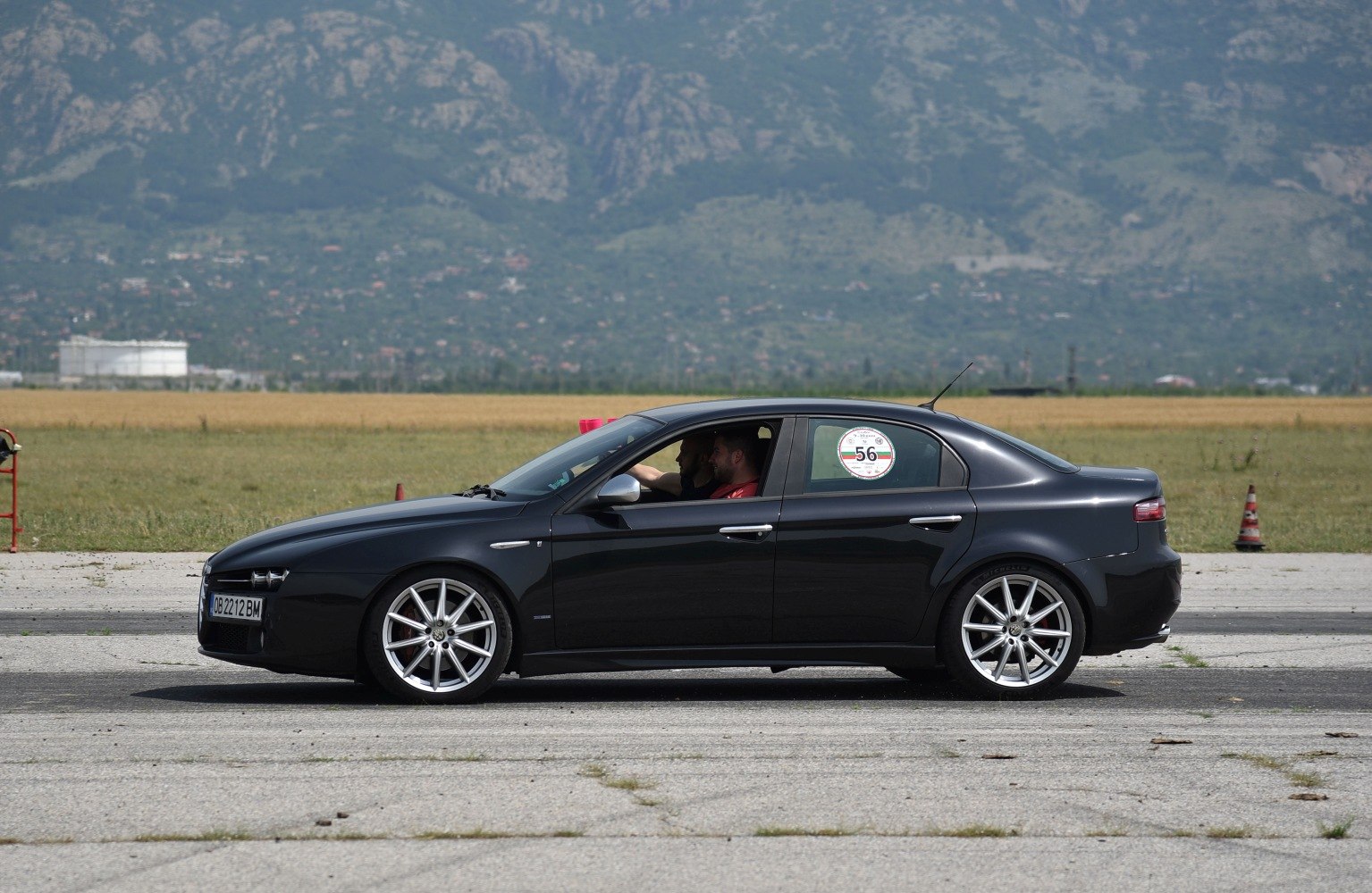 Side profile of black sedan with silver alloy wheels on tarmac