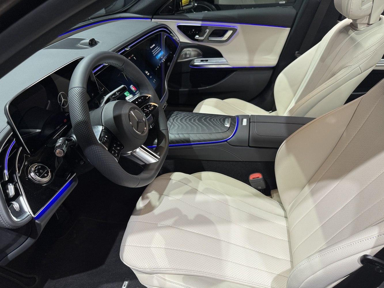 Modern luxurious car interior with digital displays and ambient blue lighting