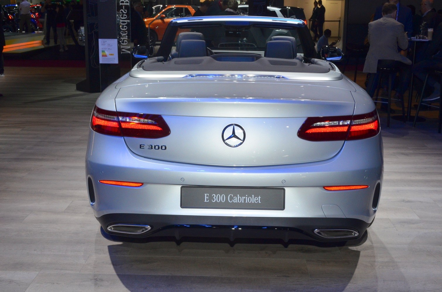 Silver convertible rear view with illuminated tail lights and dual exhausts