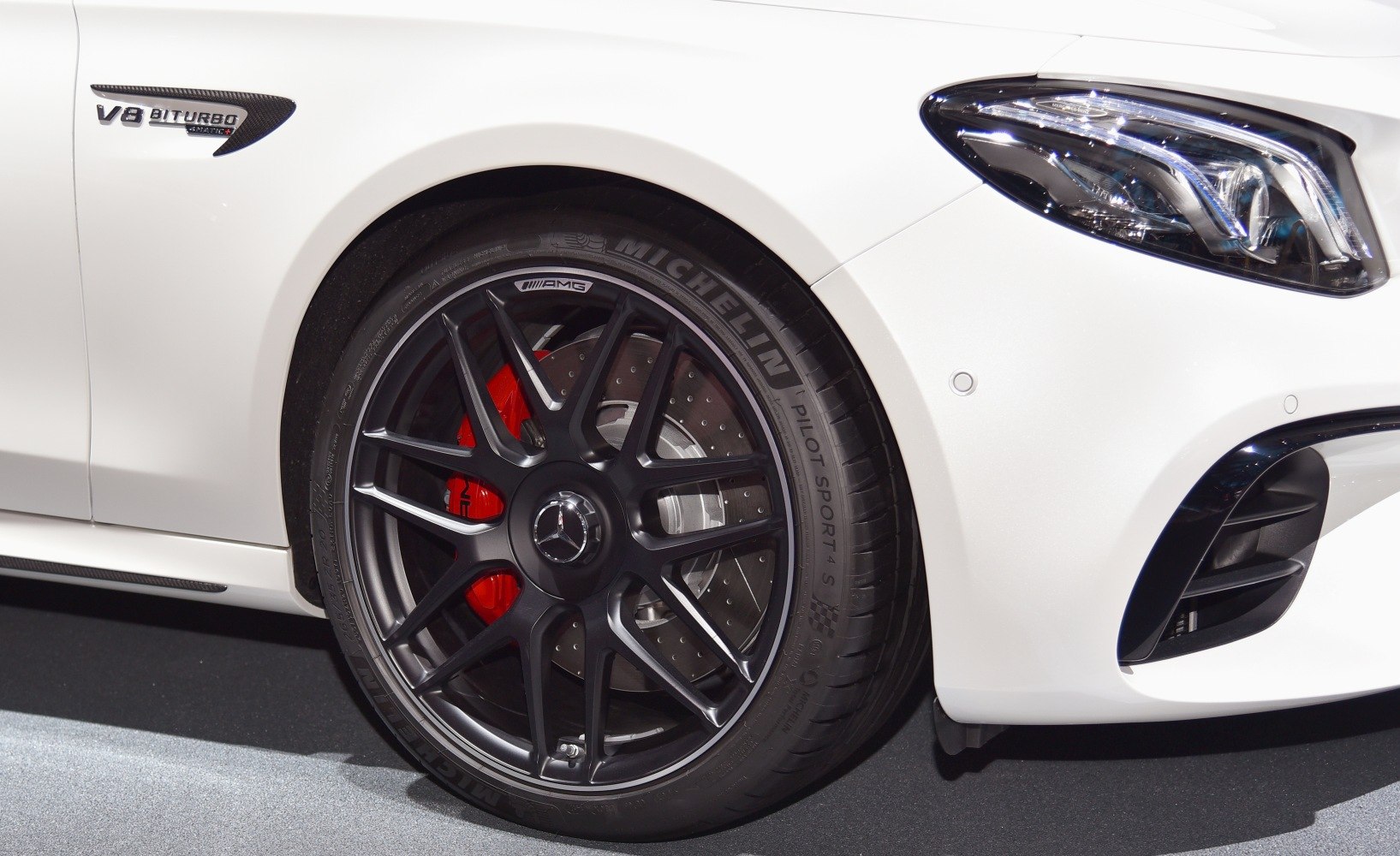 AMG alloy wheel with red brake caliper and modern headlight detail
