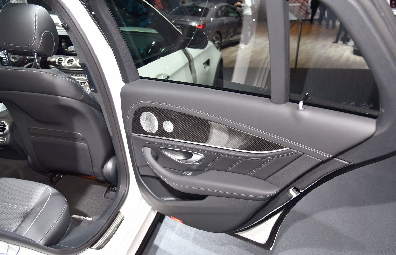 Rear door interior with leather, carbon fiber trim, and audio speaker
