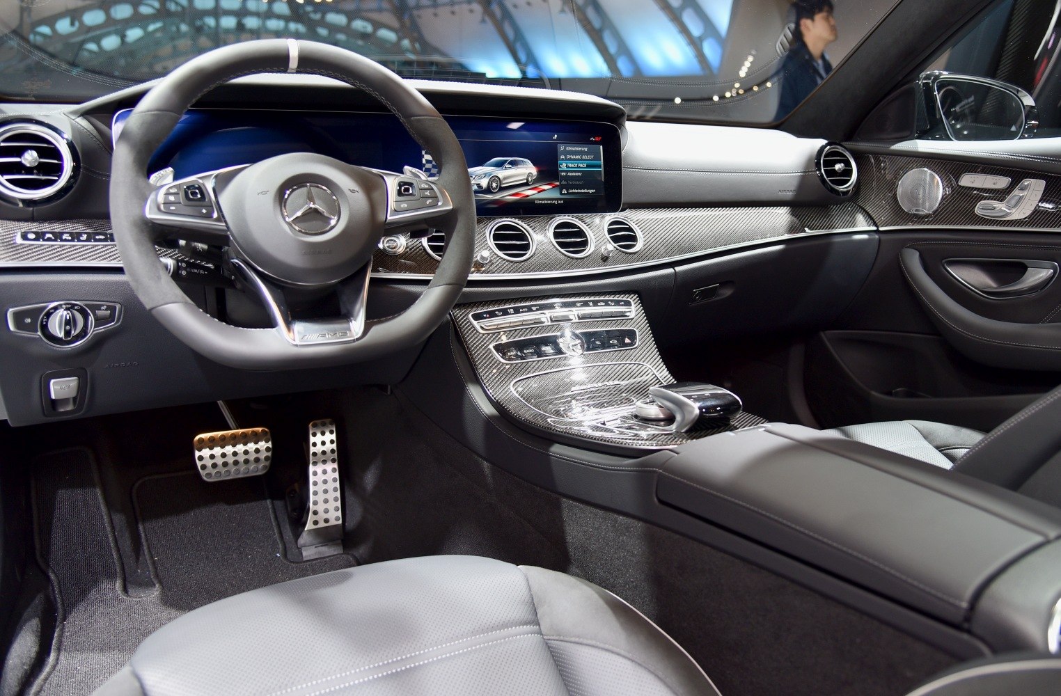 Luxury car interior with steering wheel, carbon fiber dashboard and center console