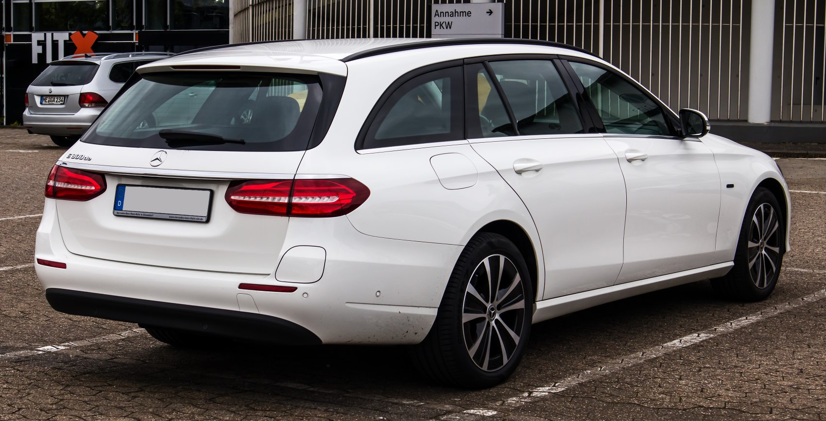 Rear and side profile of a white estate with distinct tail lights and alloy wheels
