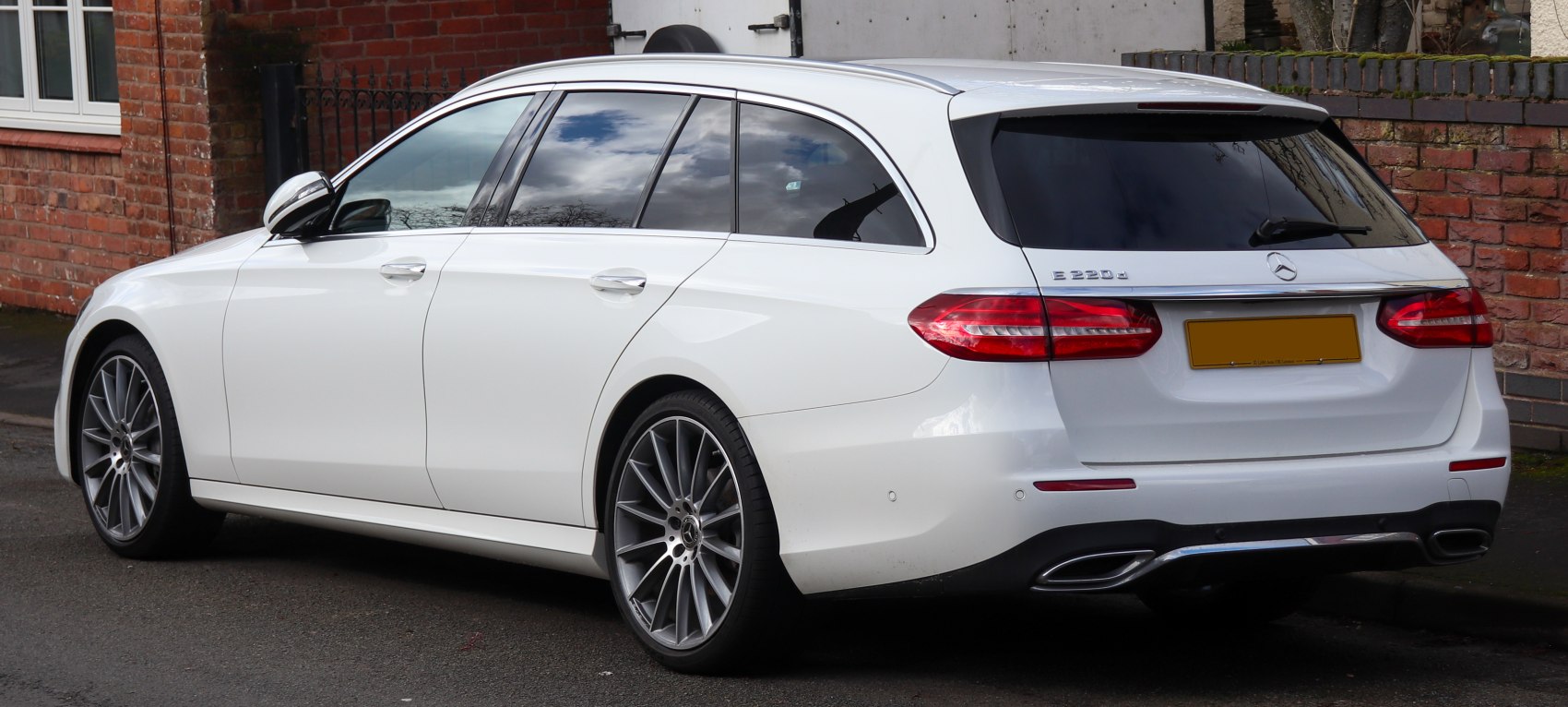 Rear and side profile of a luxury estate with sleek tail lights and alloy wheels