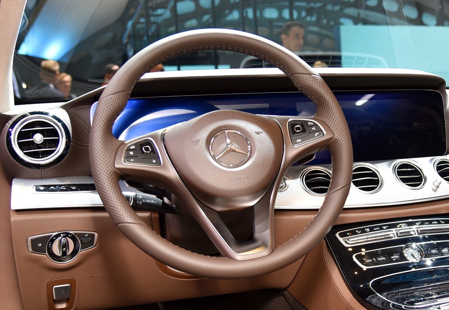 Brown leather steering wheel with digital dashboard and control panels