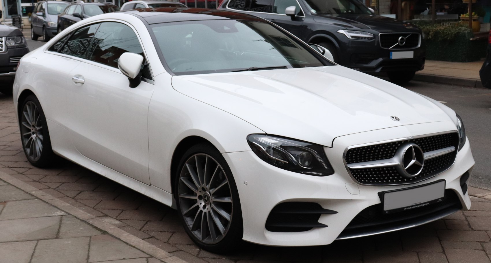 White luxury coupe with sharp LED headlights and sporty multi-spoke wheels