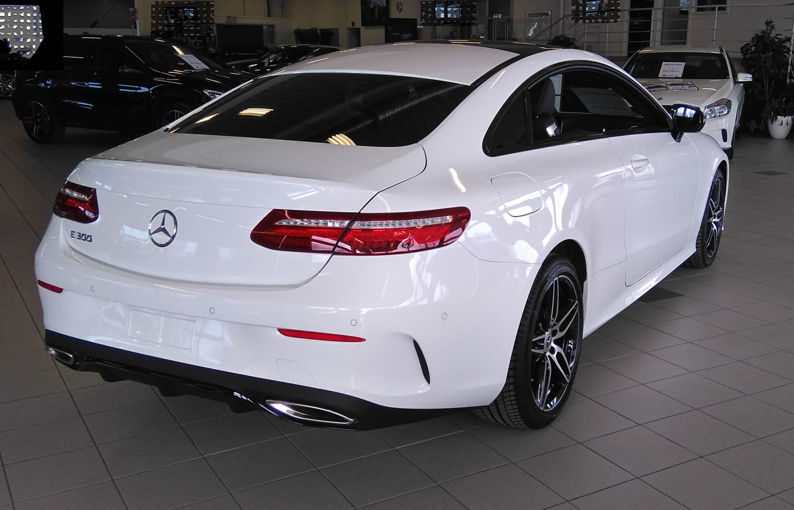 White coupe rear with sleek taillights and alloy wheels