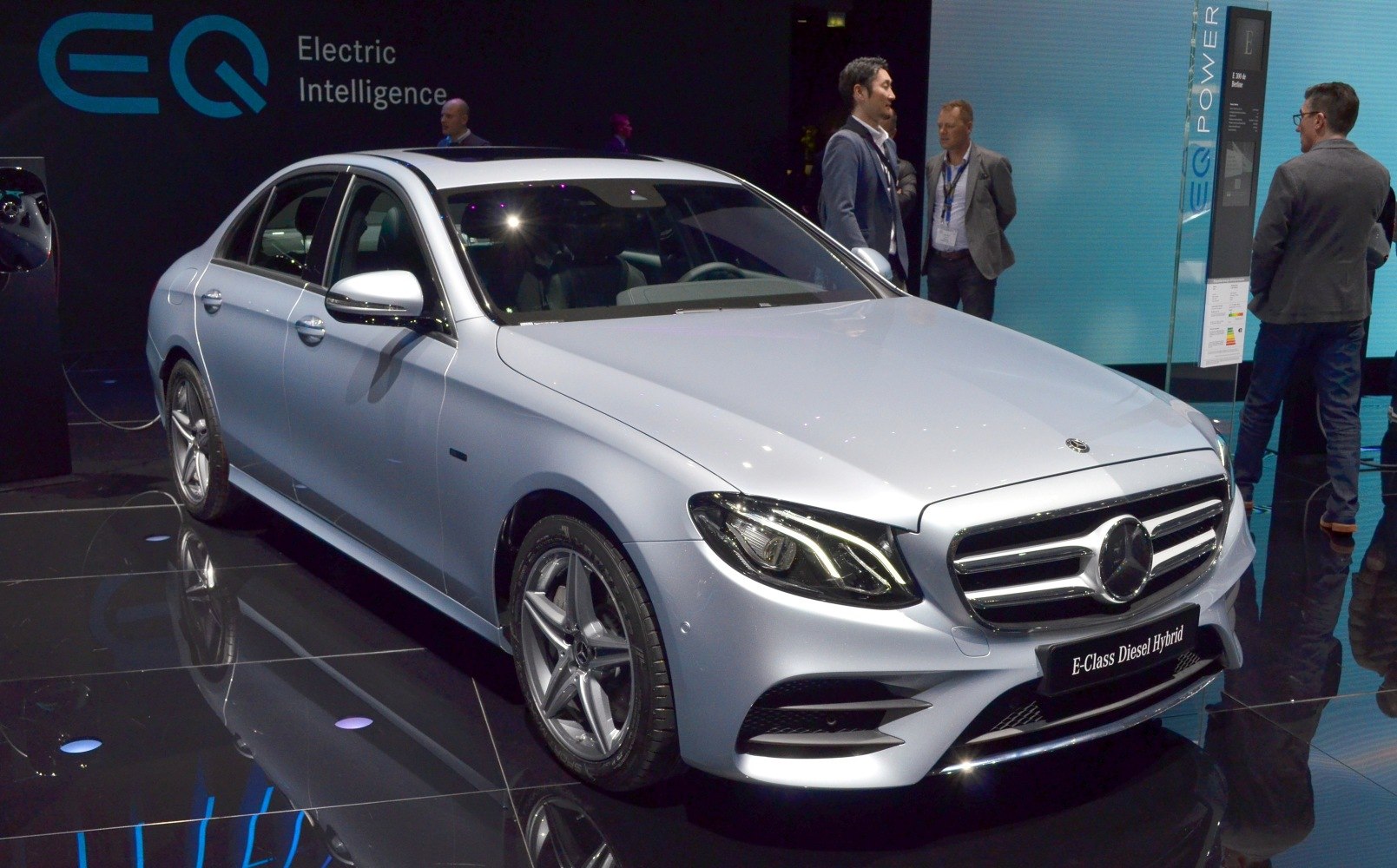 Front view of a sedan with LED headlights and alloy wheels on glossy floor