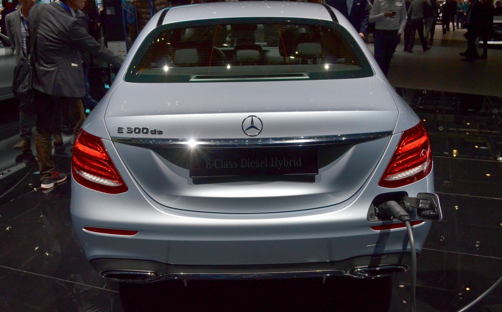 Rear view of a hybrid sedan with charging cable connected